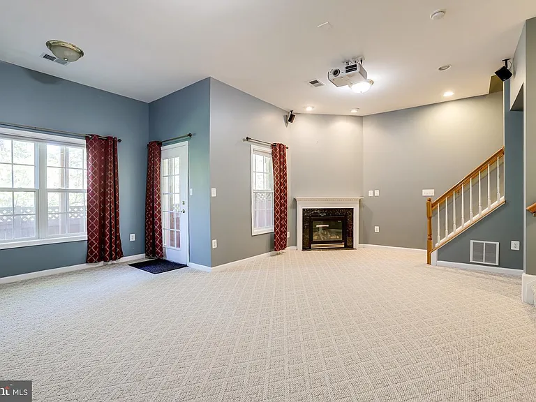 fireplace in basement with large windows overlooking trees in the private backyard