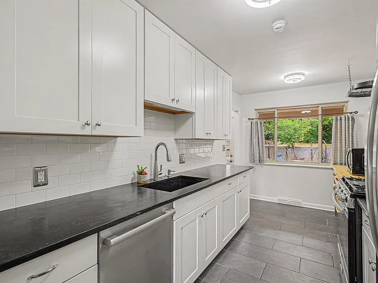 Main level kitchen with large window and views of private backyard/patio area