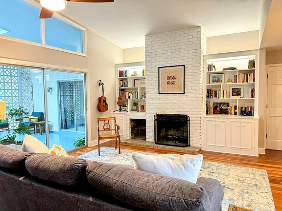 Built in bookshelves, a vaulted ceiling, sliding doors to the atrium, and a wood burning fireplace. Bonus: the lower right cabinet in the bookcase is wired and opens for your TV!