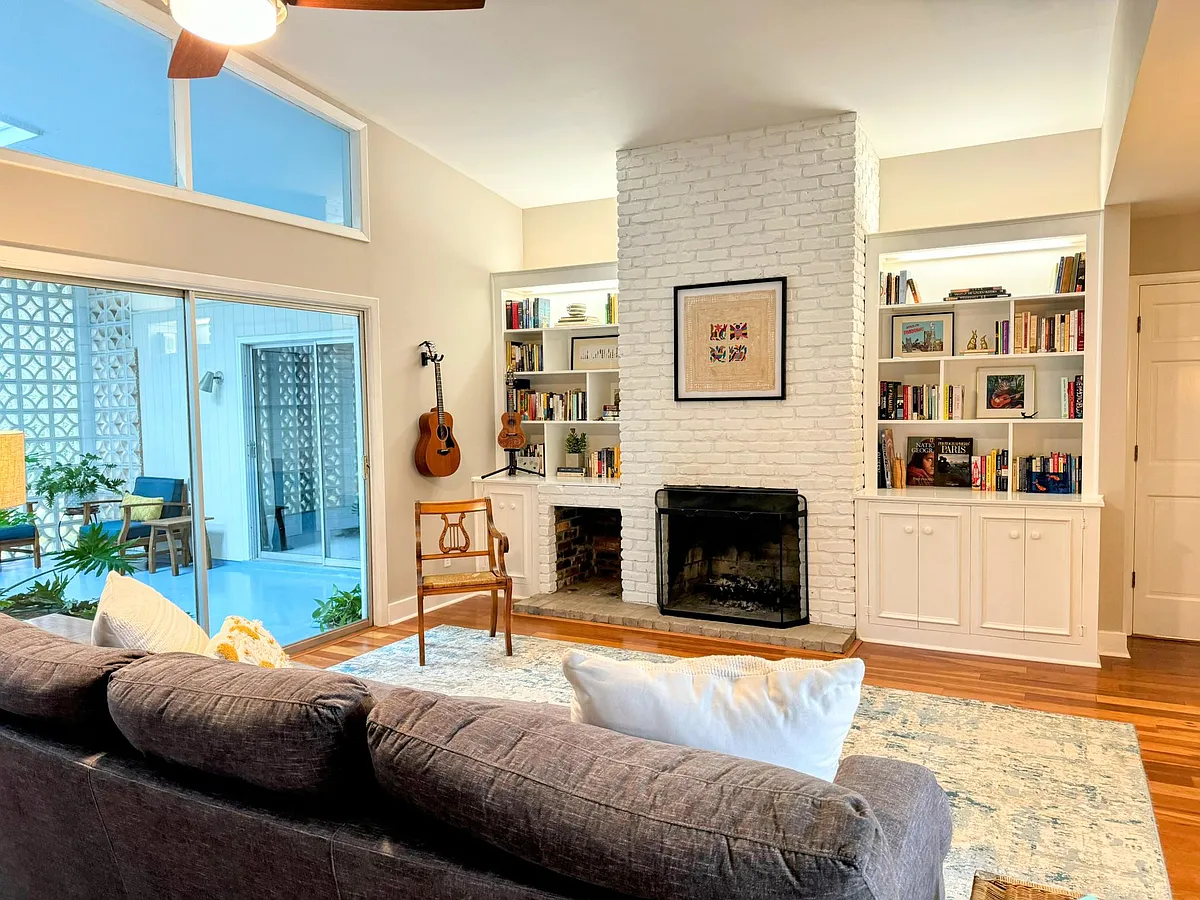 Built in bookshelves, a vaulted ceiling, sliding doors to the atrium, and a wood burning fireplace. Bonus: the lower right cabinet in the bookcase is wired and opens for your TV! - 625 Windsor Rd