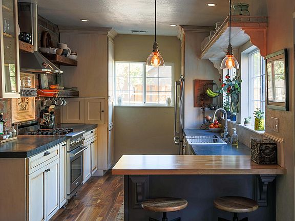 Updated kitchen with high end stainless steel appliances, custom brick wall, concrete countertops and farmhouse sink.