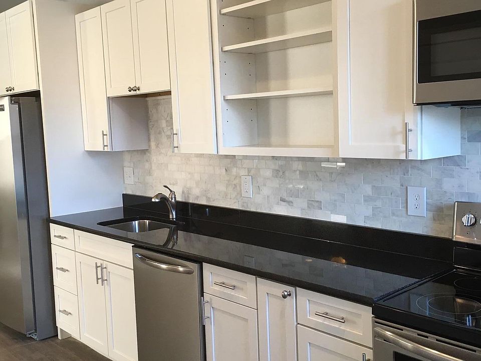 Bright kitchen with black granite countertops and marble subway tile backsplash