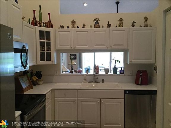 Kitchen with white cabinets, newer Stainless steel appliances has view looking out to patio and lake