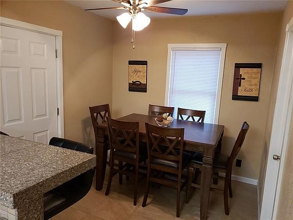 Dining room adjacent to kitchen with neutral decor.