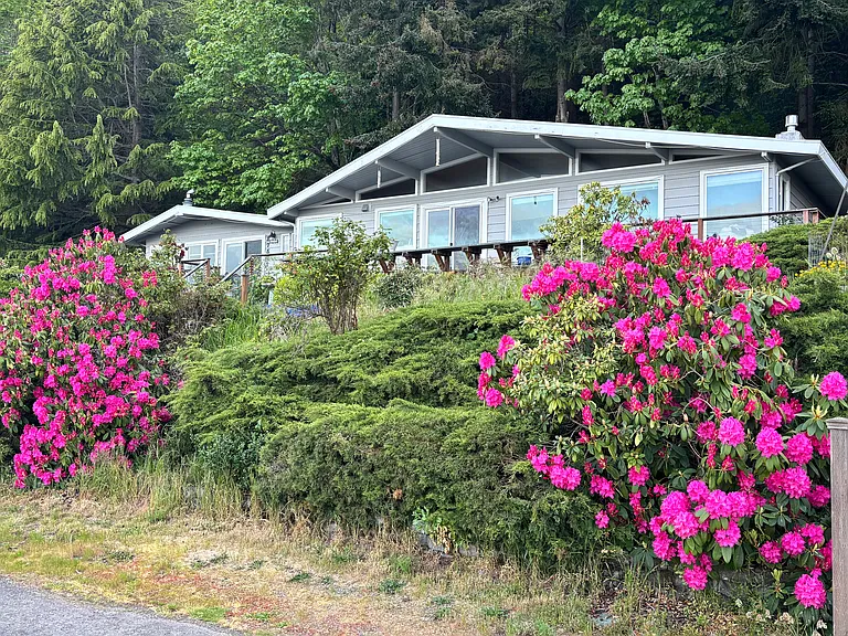 View of front of house and front deck and garden.