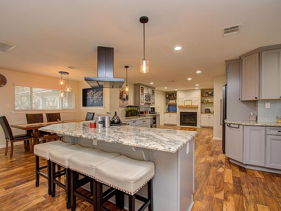 Behind the living area is a large kitchen with L-shape island with built-in, 6-cooktop gas stove and oven.