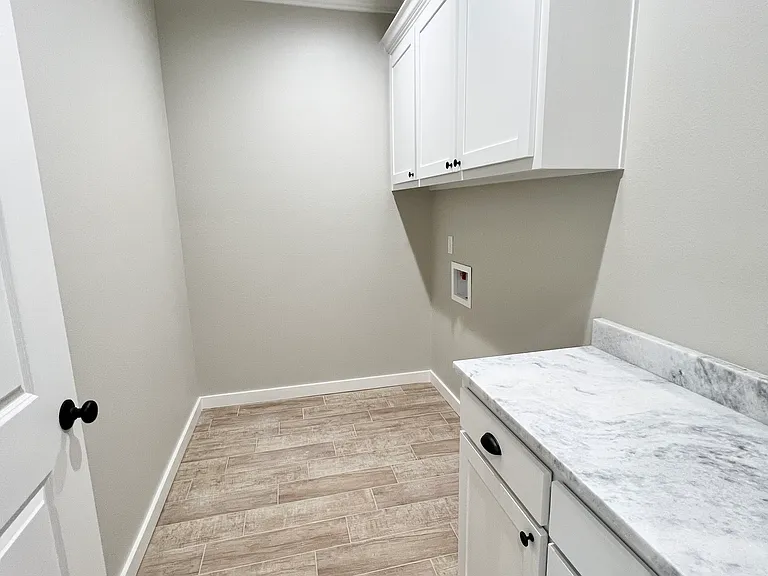 Laundry room right off the hallway coming in from the garage with a folding table