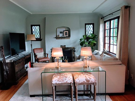 Living room. The windows in the house have all been updated except the leaded-glass windows on either side of the fireplace.