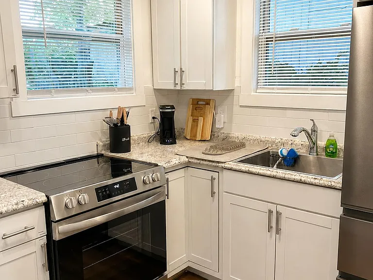 Efficient kitchen with stainless appliances, ample cabinetry, and granite-style counters plus dual windows over the sink.