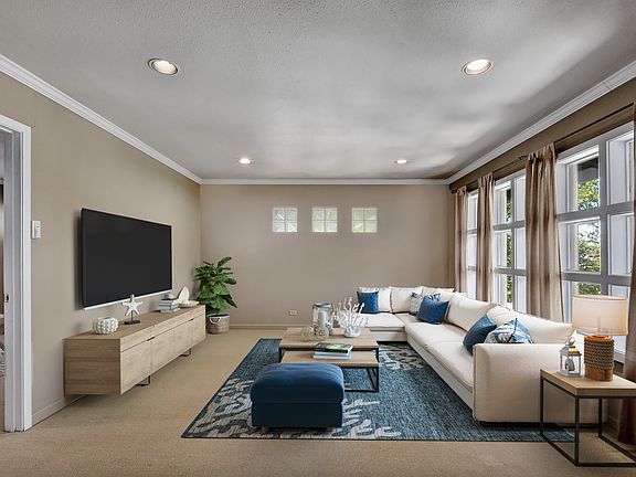 Living room with custom windows and built in recessed lighting throughout