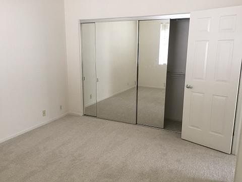 Bedroom with wall-length mirrored closet.