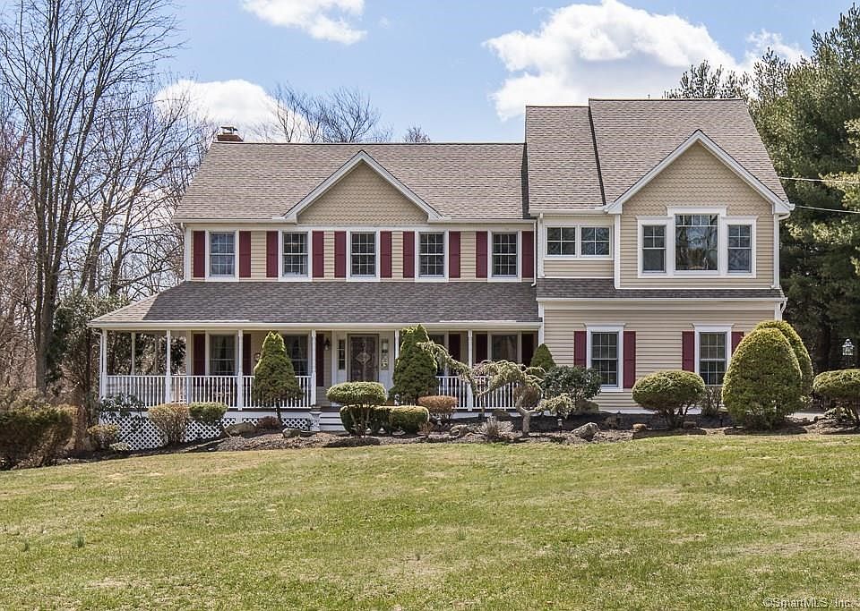Exterior front picture of 8 Punkin Patch Rd. Note the professional landscaping and the mahogany wrap-around porch.