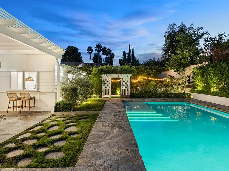Experience an oasis at night with a refreshing pool and nearby garden_a perfect setting for relaxation under the stars.