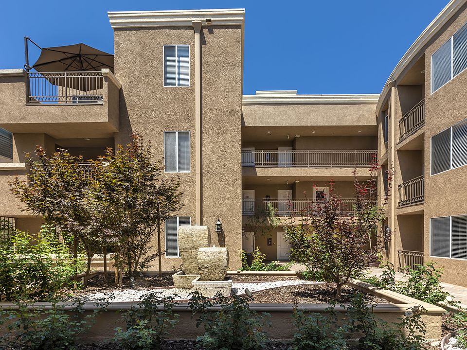 Apartments in Sherman Oaks, CA - Courtyard Art and Foliage with Surrounding Apartment Buildings.jpg