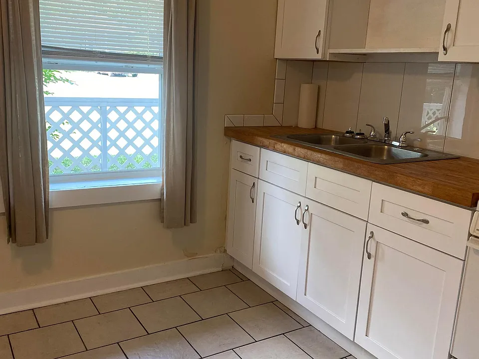 Kitchen has large window, new tile backsplash