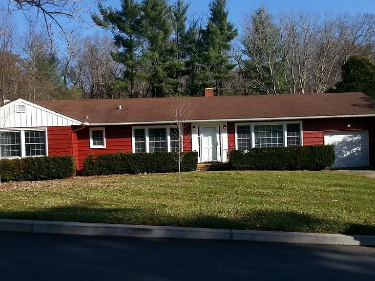 Front View - now has a metal roof. The garage door leads to a small workshop/ storage area There is no space to park a car.