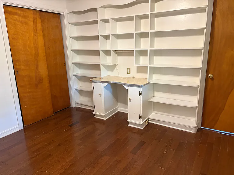 Bedroom with built in desk and book shelves