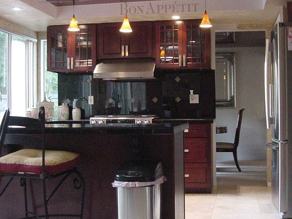 Kitchen with cherry cabinets, stainless steel appliances, granite countertops.