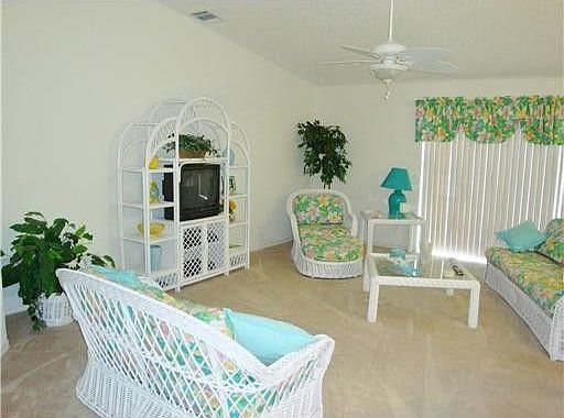 Cozy living room is fully carpeted, with full glass windows for plenty of natural light