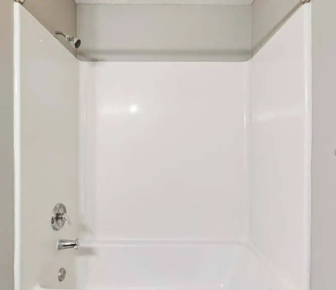 A bright, easy-to-maintain tub and shower combination offers a clean, comfortable space to refresh and recharge.