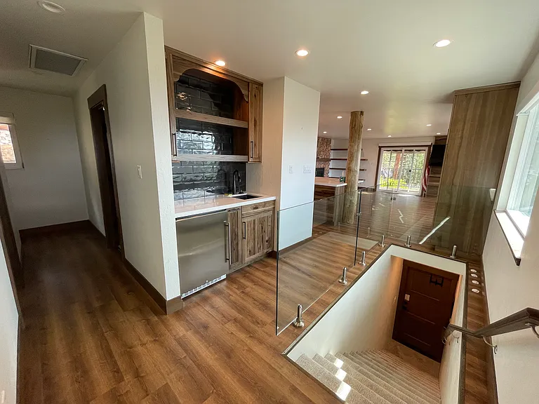 Entryway drink station with sink and refrigerator; single-level living with garage on lower level
