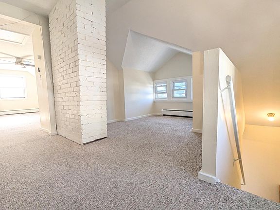 Coming upstairs to a cozy living room and very large bedroom! Very well lit, with dimmer for living space and stairs. Great nook for Television and small couch.