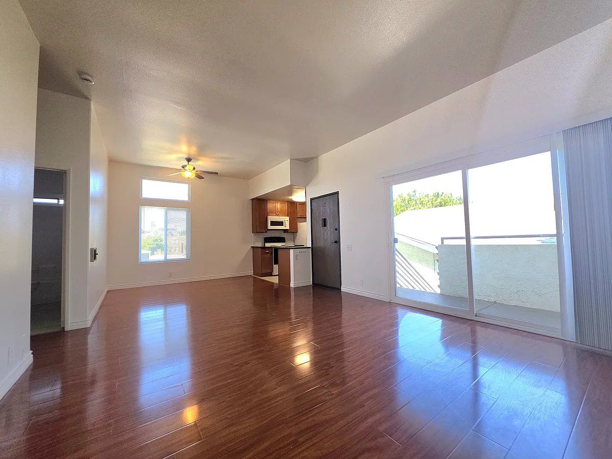 From front door, step into a spacious living room. Top floor apt with high ceilings, tons of natural sunlight. Sliding glass door to private balcony. Open kitchen and dining area and ceiling fan. - 3672 Georgia St #C-6