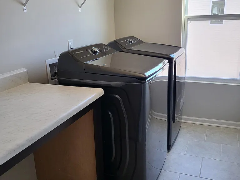 Laundry room with folding area and storage closet