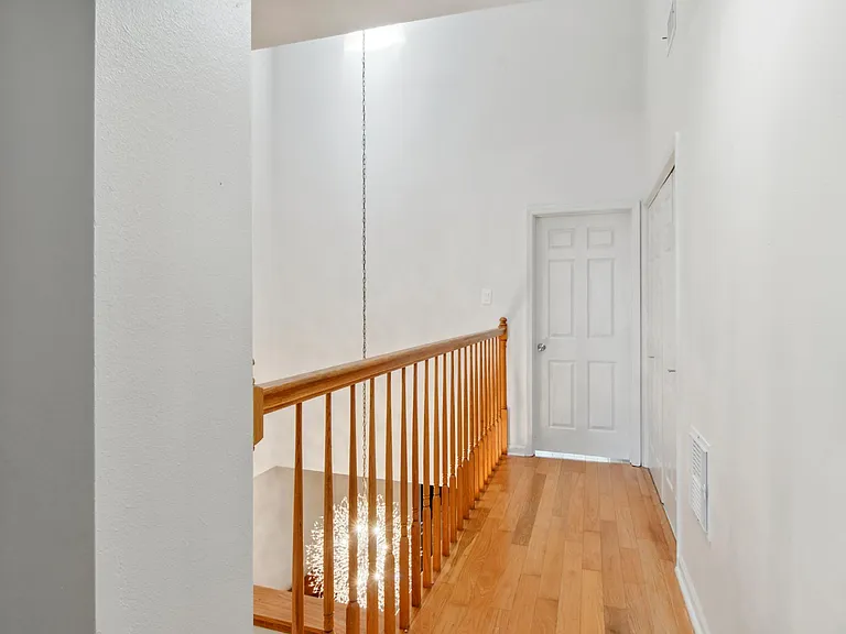 Upstairs hallway between Master Bedroom and Front Bedroom. The balcony overlooks the Dining Room that is under a skylight.