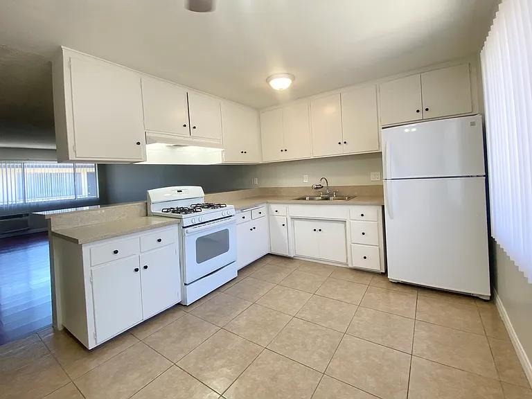 Generous sized eat-in kitchen with 30 inch gas range with mechanical hood, double stainless steel sink, and 34 inch refrigerator provided.