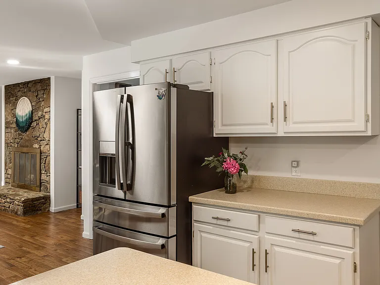 Large refrigerator and tons of cabinets for storage.