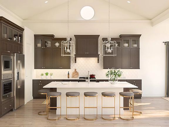 Kitchen with island, pendant lighting, glass-front upper cabinets and volume ceiling