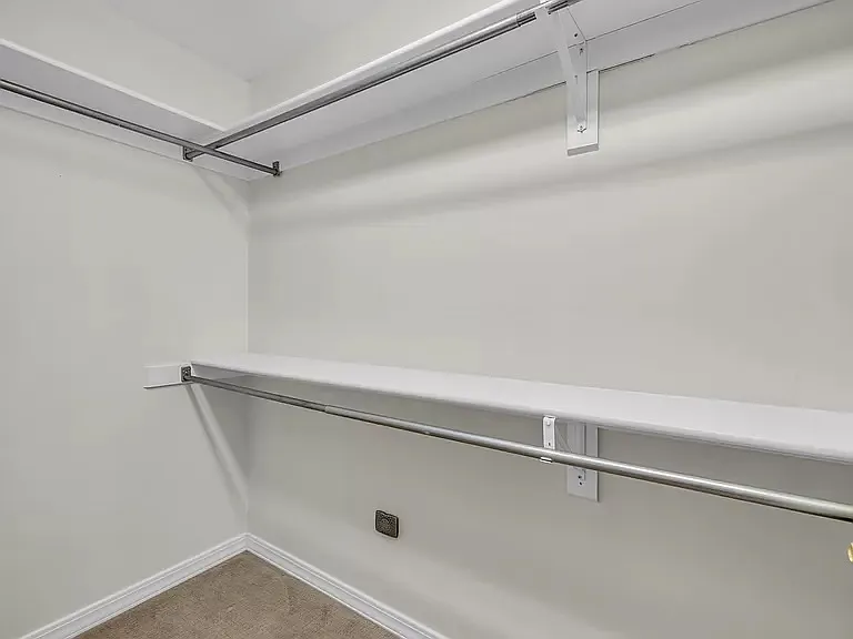 Large walk in closet with custom shelving