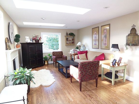 open great room with fireplace, skylights and large windows