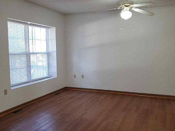 Living room has vinyl flooring, a ceiling fan & royal blue accent wall (not shown in picture).