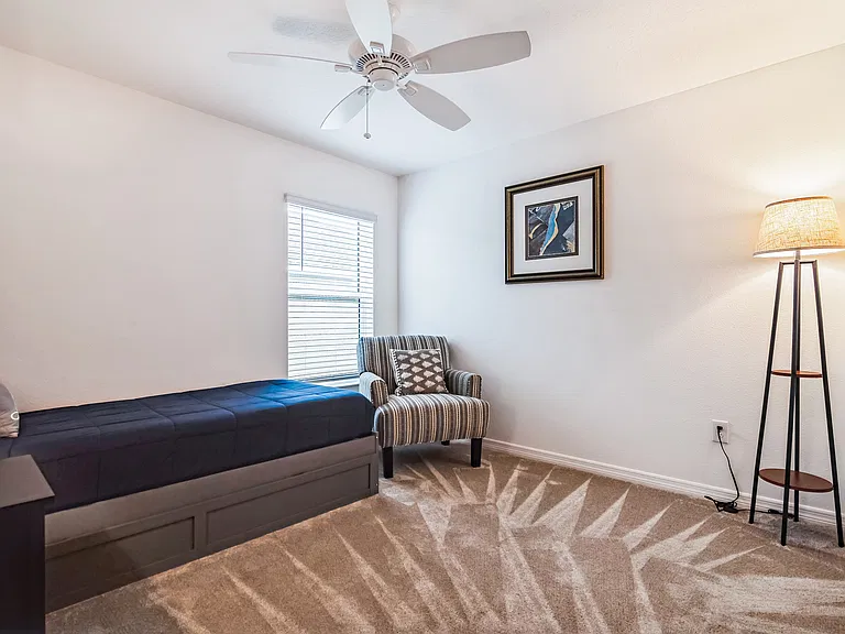 Secondary Bedroom with a View to the Side Yard and a Ceiling Fan.