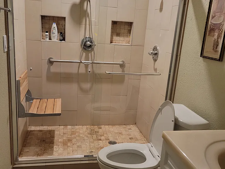 Shower with 2 shower heads and toilet in primary bathroom.