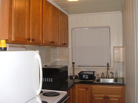 Kitchen with full Refrigerator, Stove, Microwave, plenty of cabinet space and granite counter tops.