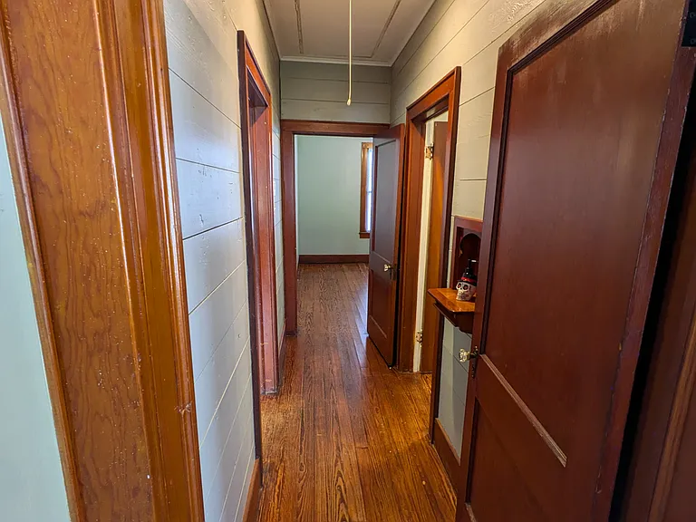 Hallway showing attic access & HVAC filter. Aluminum pull-down stair provides safe access to attic storage.