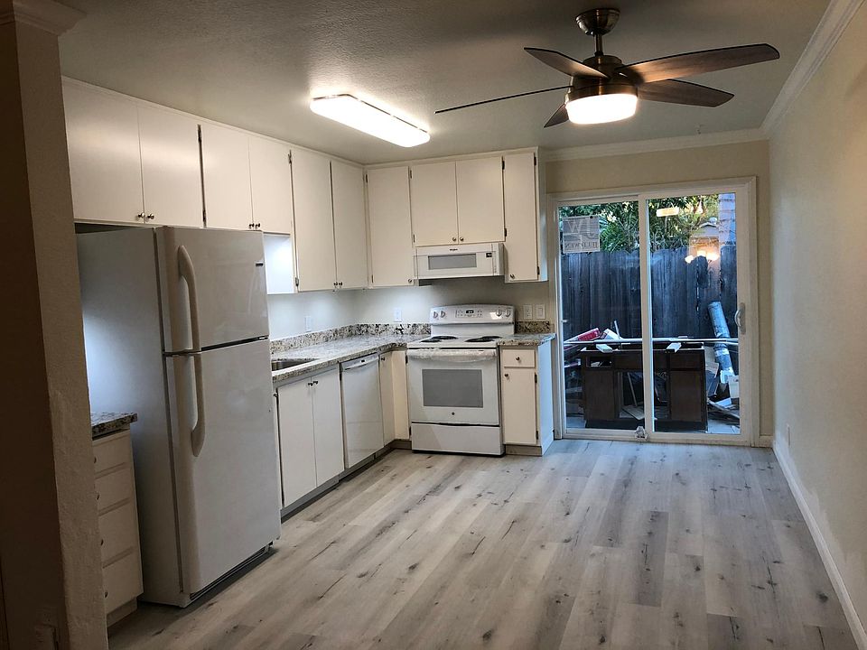 Kitchen with newer ceiling fan and LED light, newer sliding glass door and screen, newer vertical blinds.