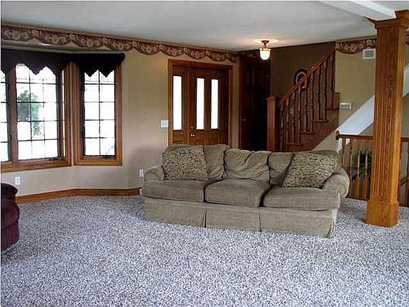 View of front entry and staircase to upper level from fireplace