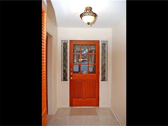 Foyer with updated light fixture with living/dining combo to the left.