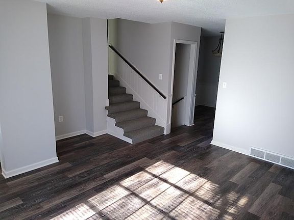 Front Living Room. (Stairs up to 2 bedrooms, 1 bathroom and linen closet. Stairs down to Family Room and Garage level)