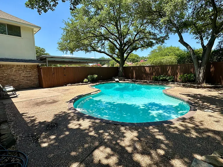 View of pool and patio with a fenced in backyard