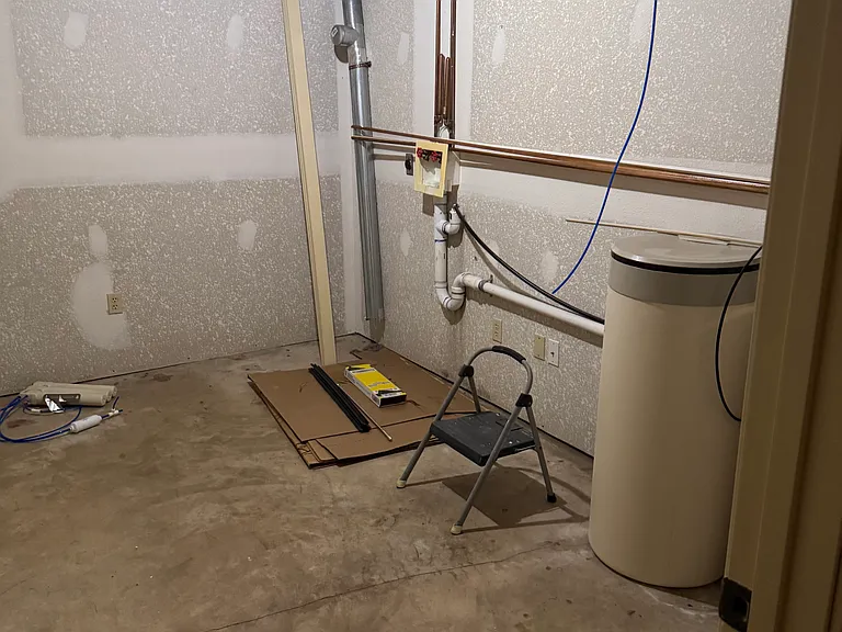 Utility room with washer and dryer hookups, water softener and under the stairs closet for storage.