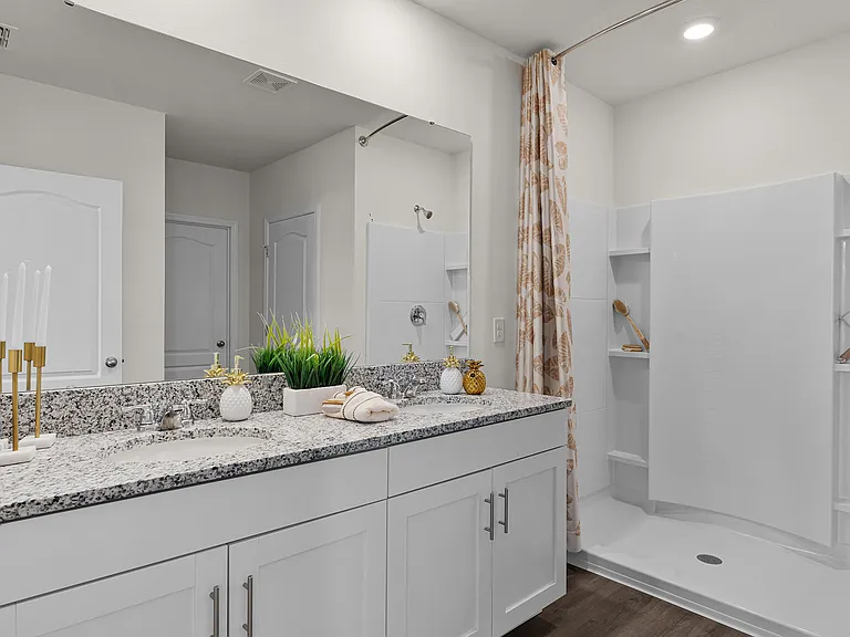 Bright and spacious bathroom with dual-sink vanity and walk-in shower.