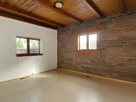 Larger bedroom has wood-veneer floor. Suitable for a bedroom or office.