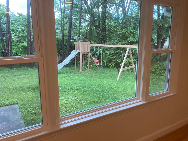 View of backyard from dining room, viewing outdoor playset.