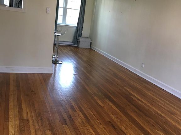 Living room with a view of the dining room. There is a window into the kitchen.