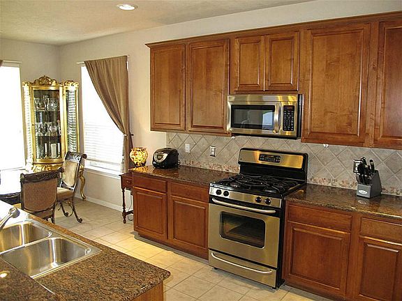 The kitchen also features ceramic tile and flooring and backsplash.